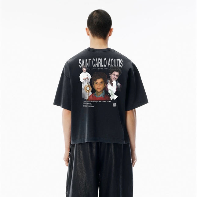 Person wearing a vintage black t-shirt of St. Carlo Acutis graphic.